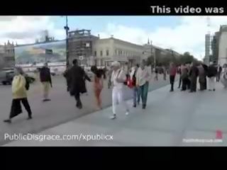 عار مقيد امرأة سمراء يمشي في الهواء الطلق في ال الشوارع